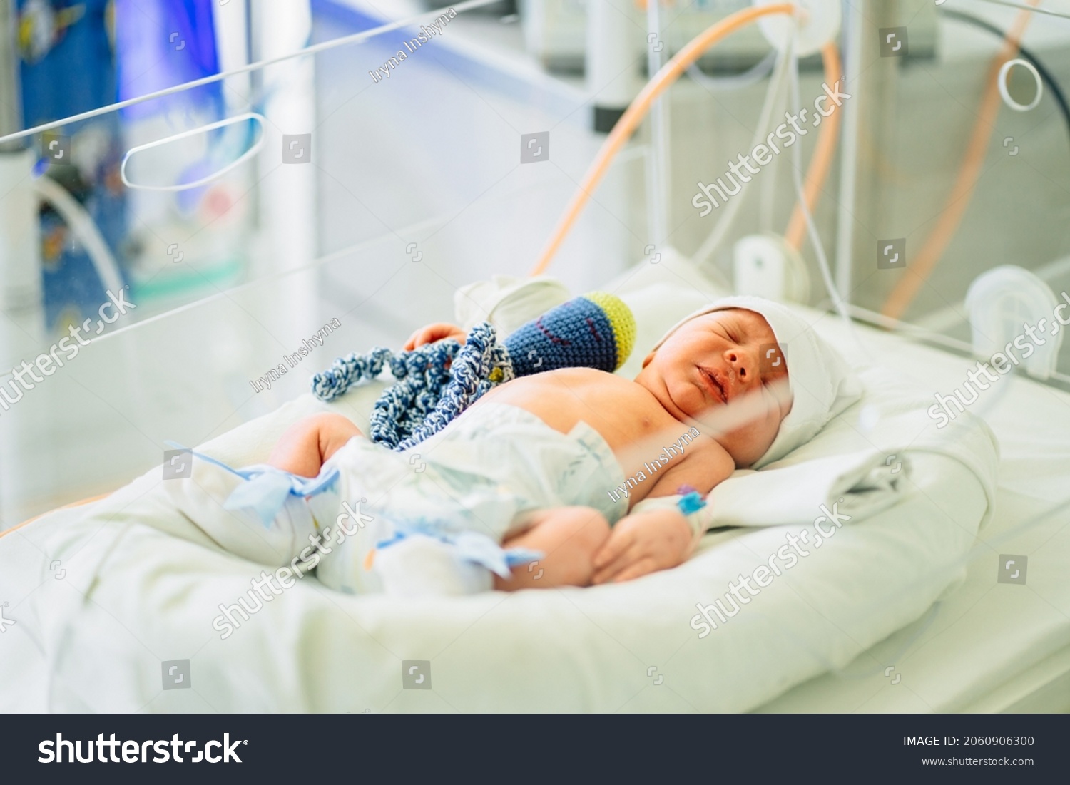 Two-day-old newborn baby boy in intensive care unit in a medical incubator. Newborn rescue concept. The work of resuscitation doctors. Photo indoors. #2060906300