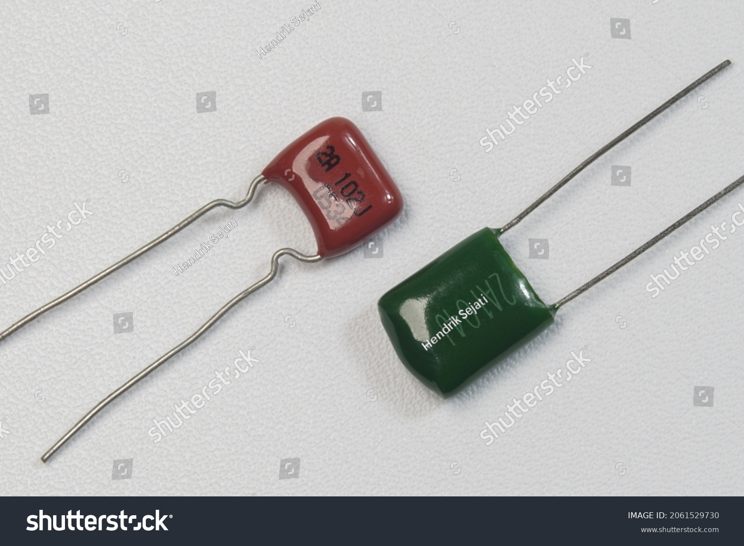 Red and green mylar capacitors on white background isolated. Closeup macro shots. #2061529730