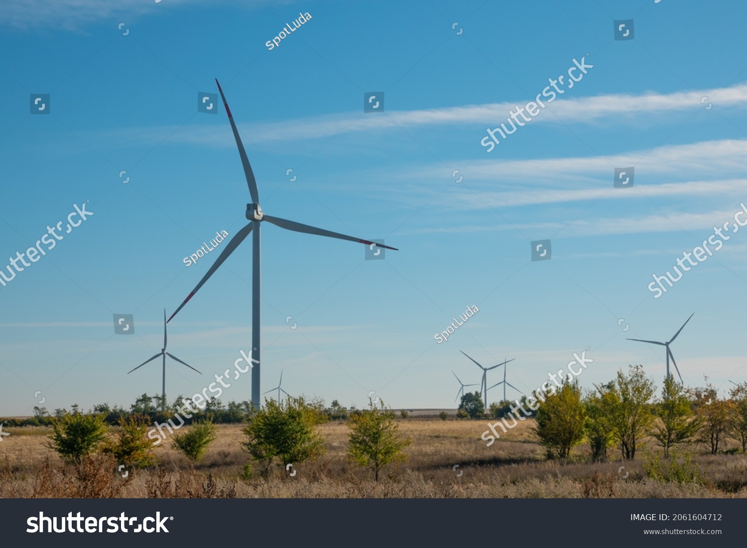 Wind turbines in open terrain on windy days with dark clouds in the sky. Alternative power generation. Copy space. #2061604712