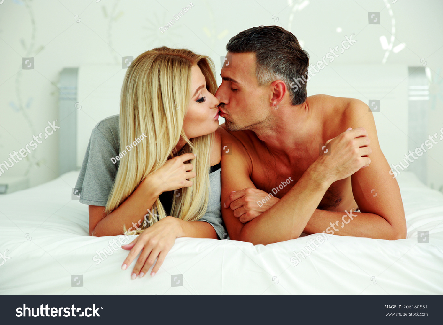 Loving young couple lying on the bed and kissing  #206180551