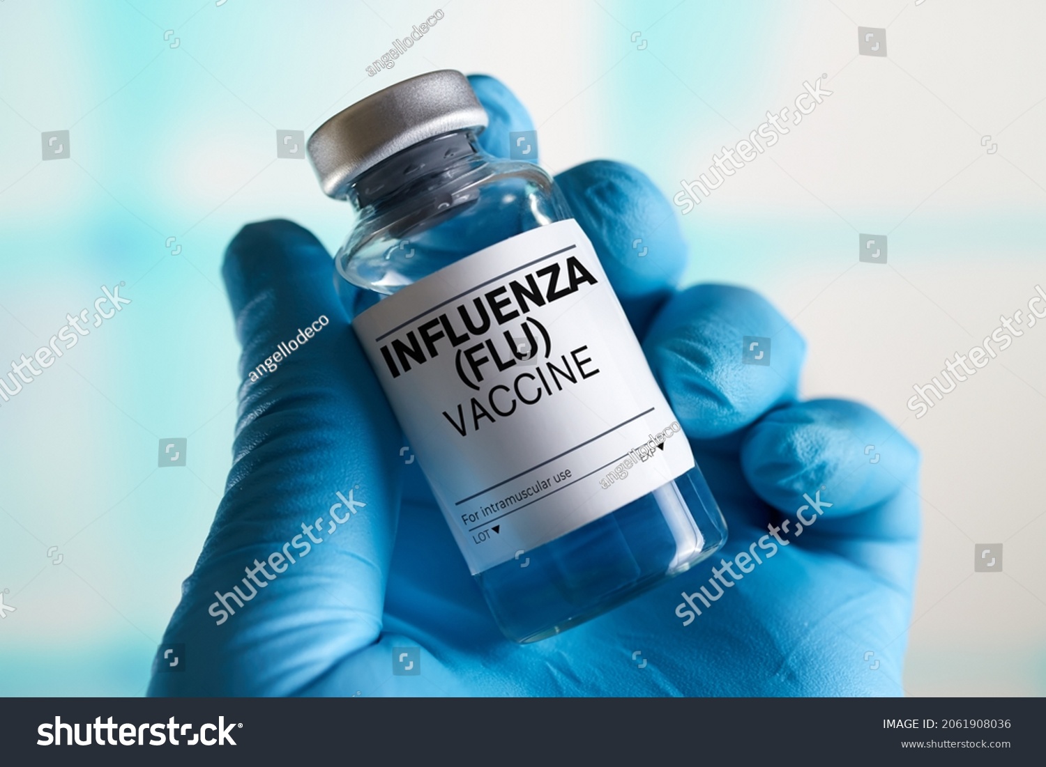 doctor with Influenza Flu or Grippe vaccine bottle for the annual flu disease prevention campaign. Influenza (Flu) Vaccine vial #2061908036