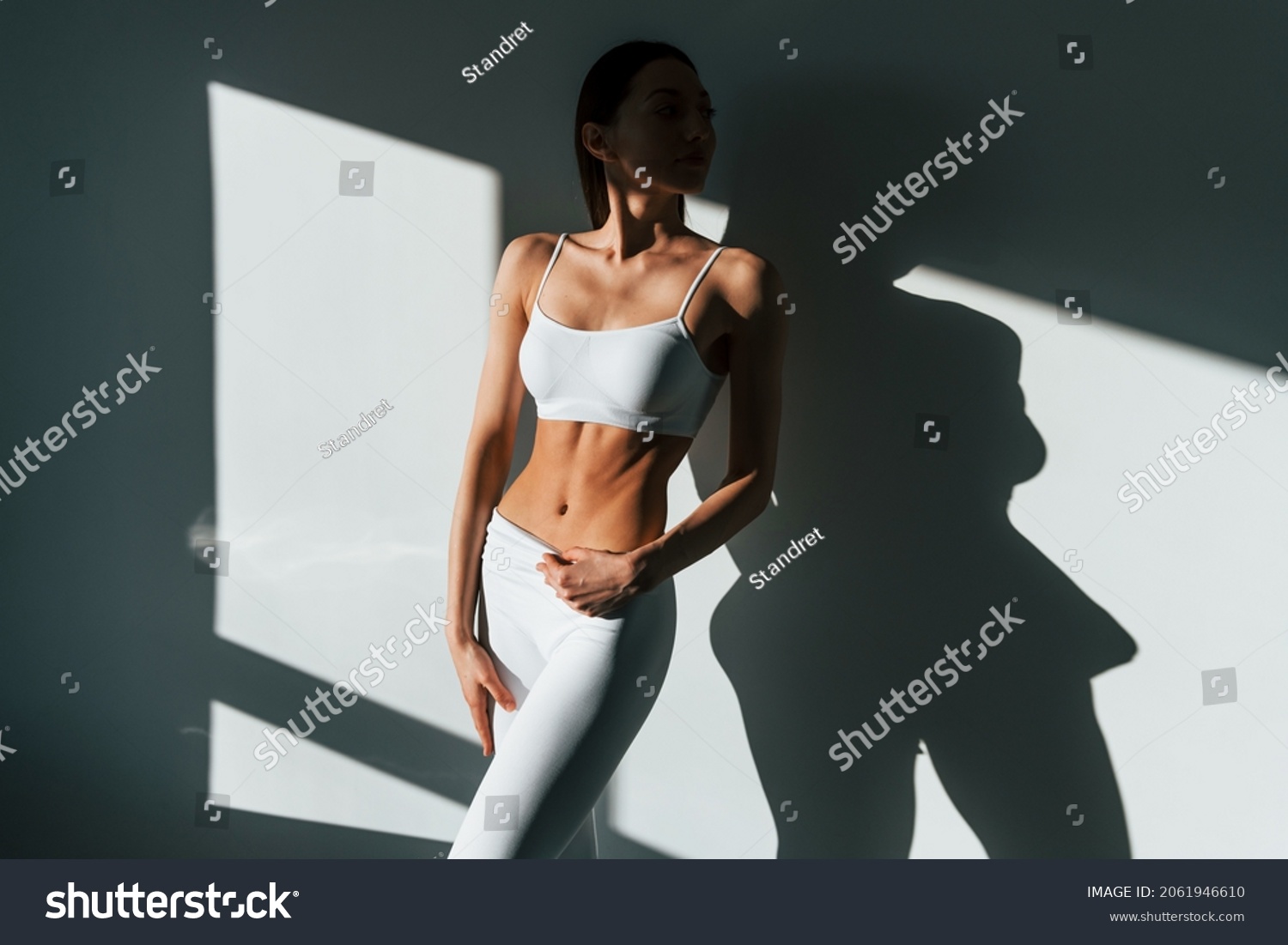 Beautiful lighting. Young caucasian woman with slim body shape is indoors at daytime. #2061946610