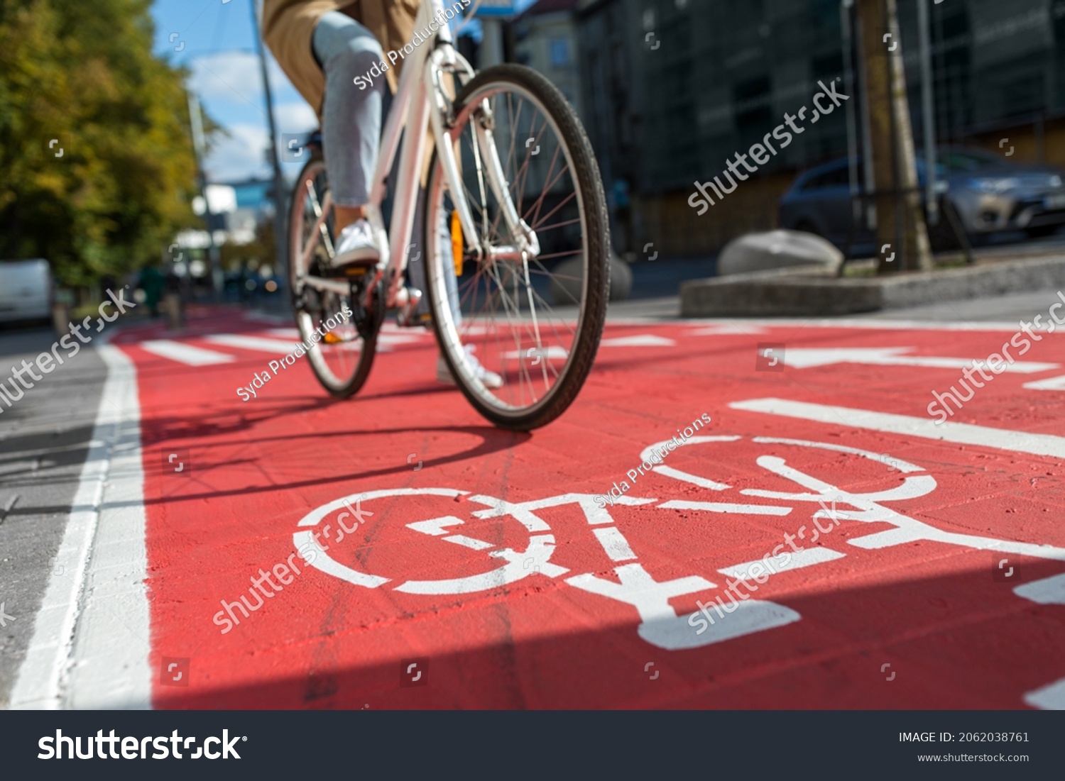 traffic, city transport and people concept - woman cycling along red bike lane with signs of bicycles on street #2062038761