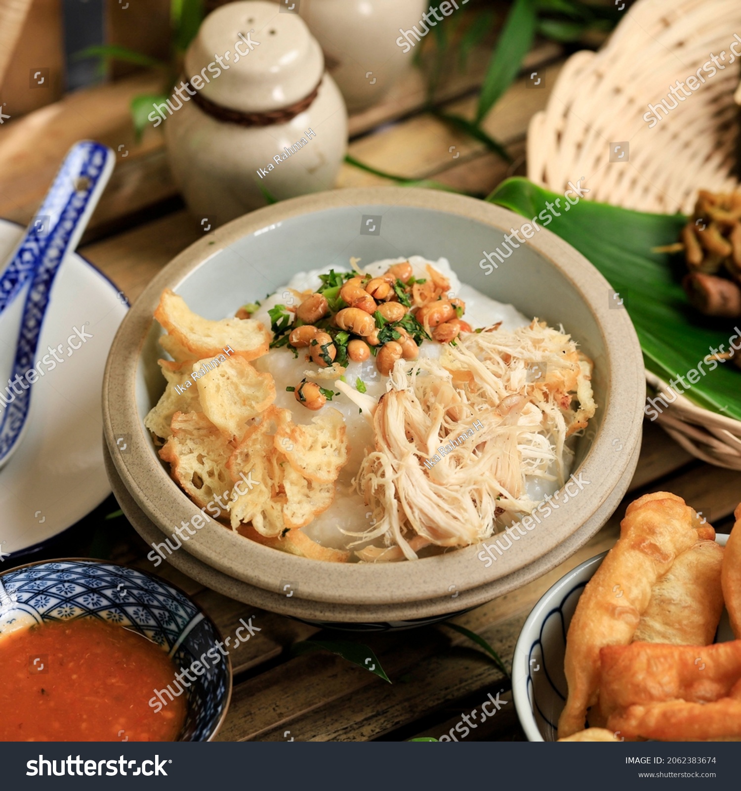 Bubur Ayam or Indonesian Rice  Porridge with Shredded Chicken. Served with Kerukpuk (Cracker), Soy Sauce, Fried Soy Bean, and Sambal #2062383674
