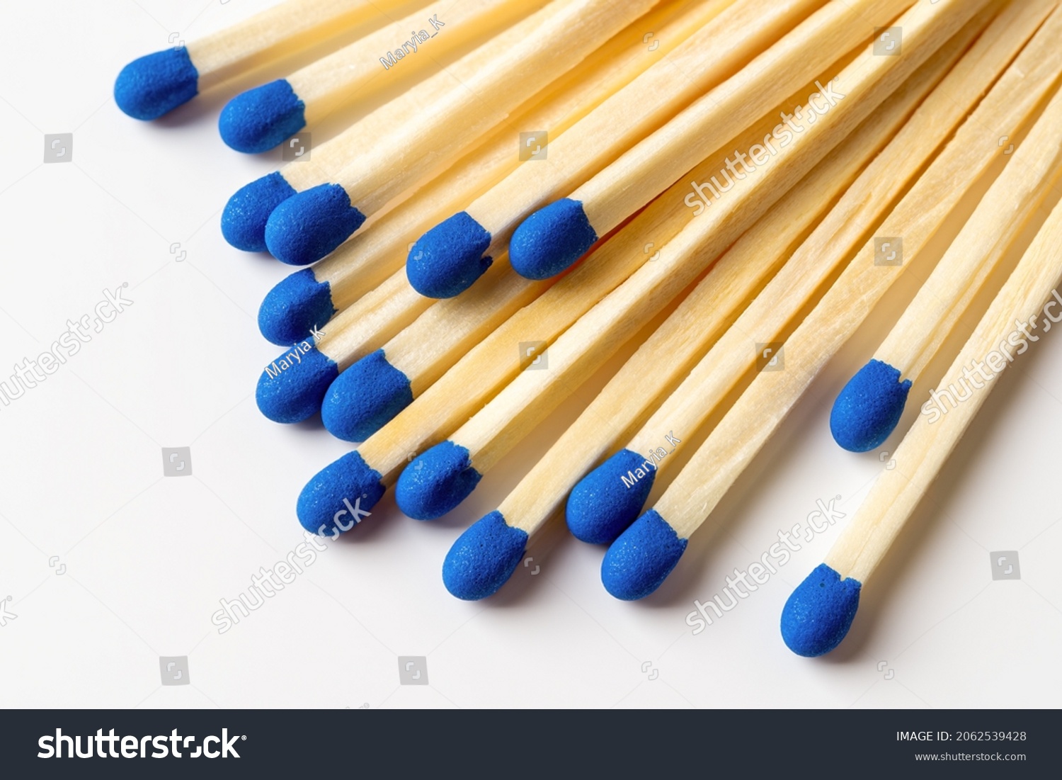 Blue wooden matches on a light gray background. Matchsticks with bright blue heads macro. Scattered wooden matches without box close-up. Design element for smoker accessory concept. Top view. #2062539428