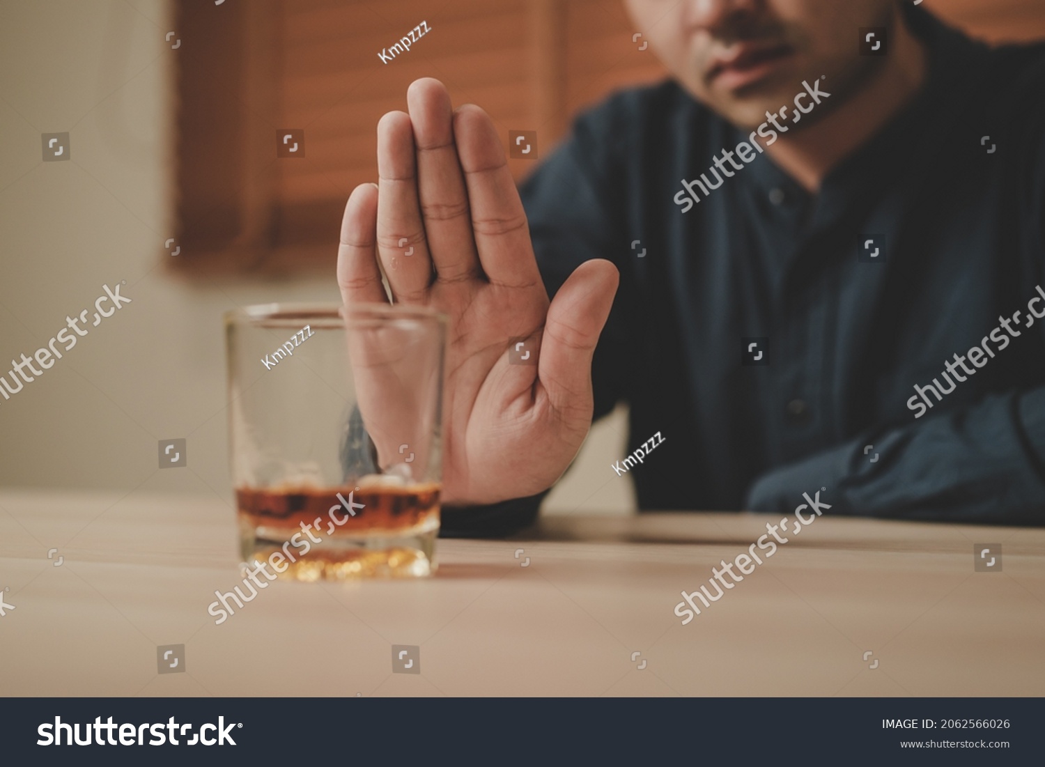 Alcoholism, sad depressed asian young man refuse, push alcoholic beverage glass, drink whiskey, sitting alone at night. Treatment of alcohol addiction, having suffer abuse problem alcoholism concept. #2062566026