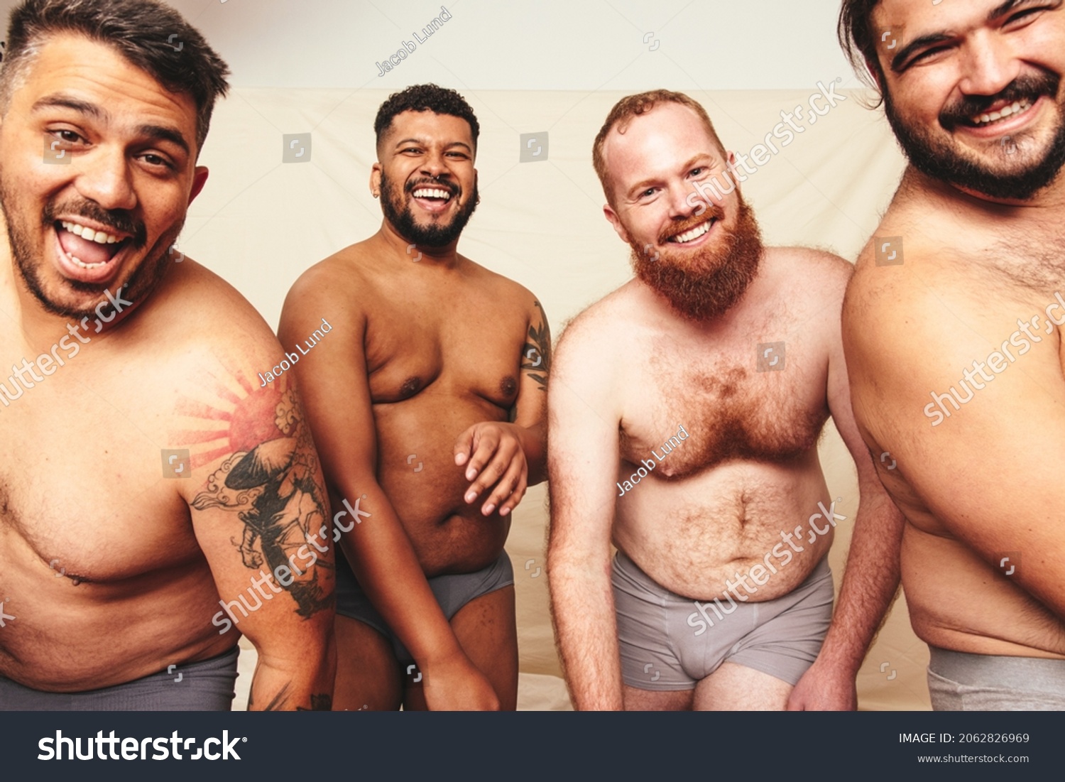 Having fun while shirtless. Three happy men smiling at the camera while wearing underwear in a studio. Body positive and self-confident men celebrating their natural bodies. #2062826969