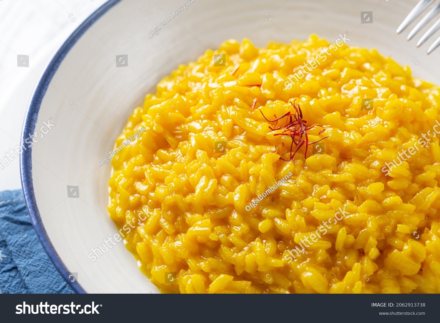 Risotto allo Zafferano. Italian dish made from saffron, rice and vegetable bouillon. Close-up. #2062913738