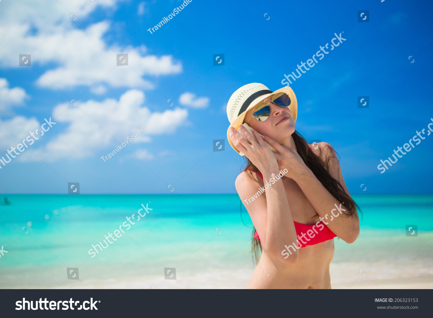 Beautiful girl with seashell in hands at tropical beach #206323153