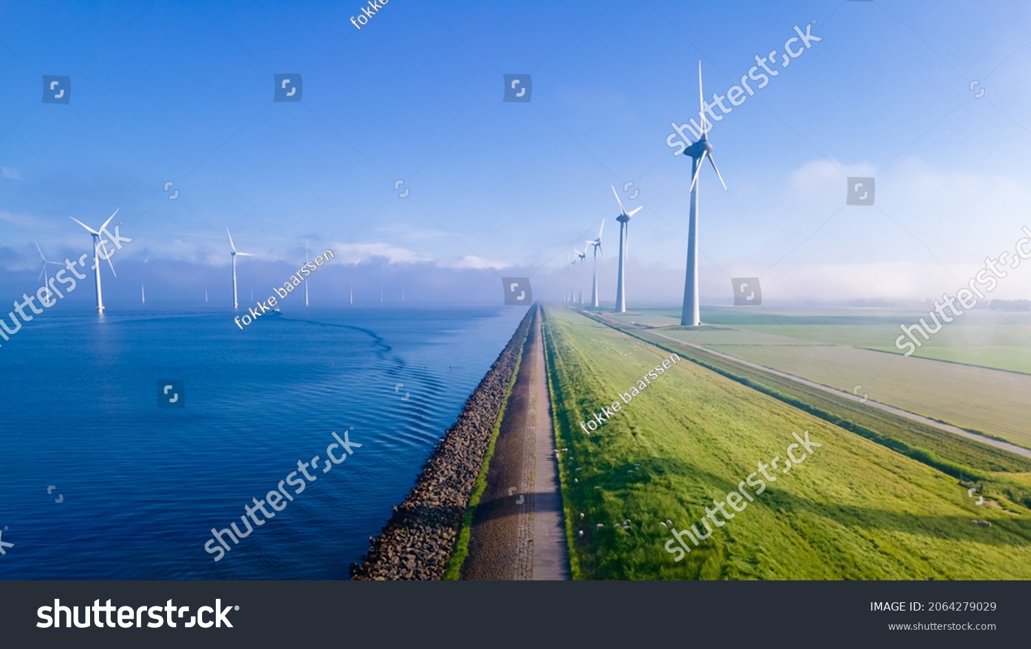 offshore windmill park with clouds and a blue sky, windmill park in the ocean aerial view with wind turbine Flevoland Netherlands Ijsselmeer. Green energy  #2064279029
