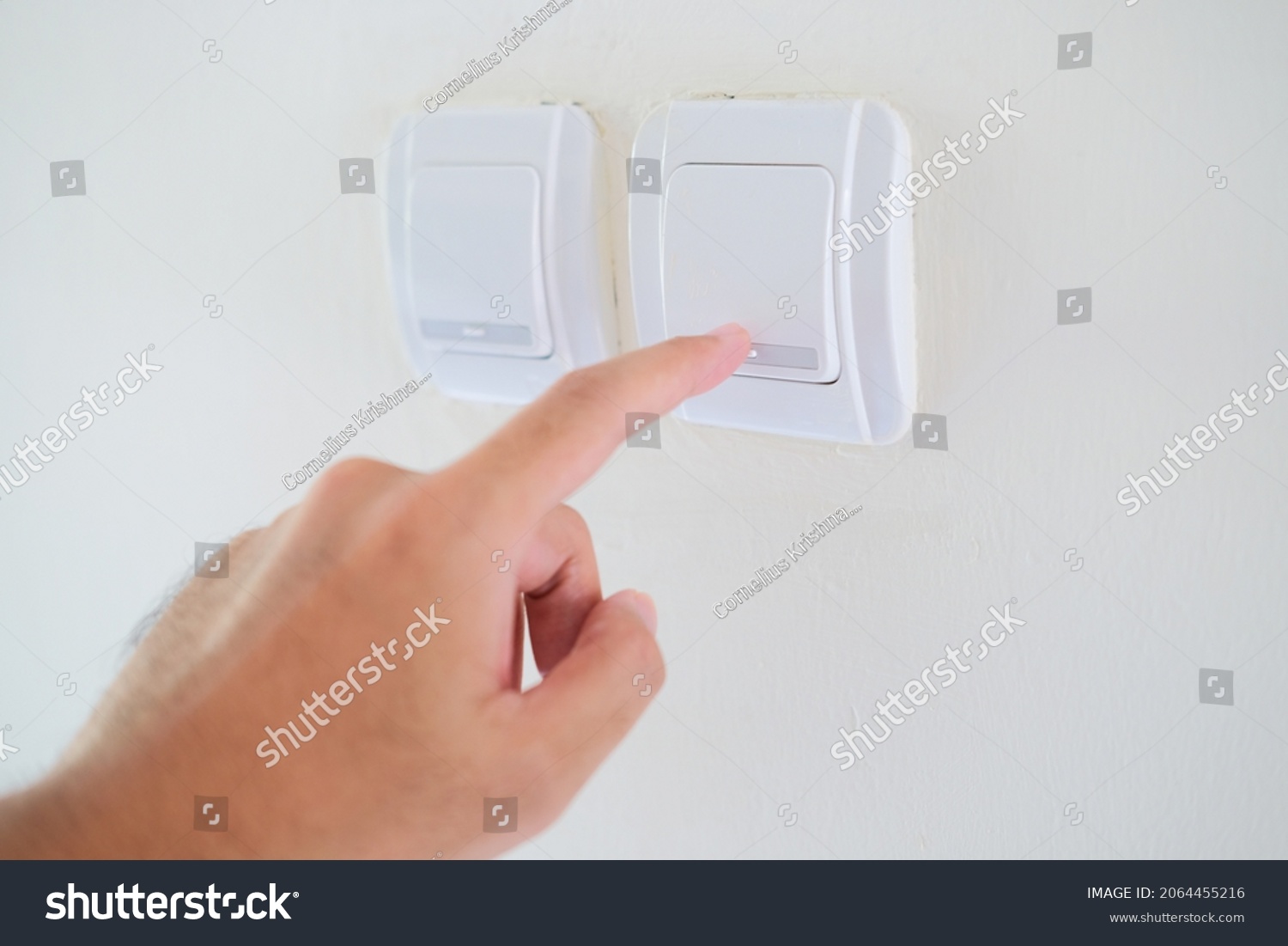 Person hand pressing home lamp switch button #2064455216