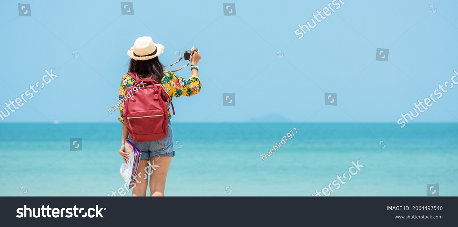 Happy traveler and tourism women travel summer on the beach.  Asia smiling people holding map and camera take photo  and relax outdoor for destination and leisure trip travel holiday.Summer Vacation #2064497540
