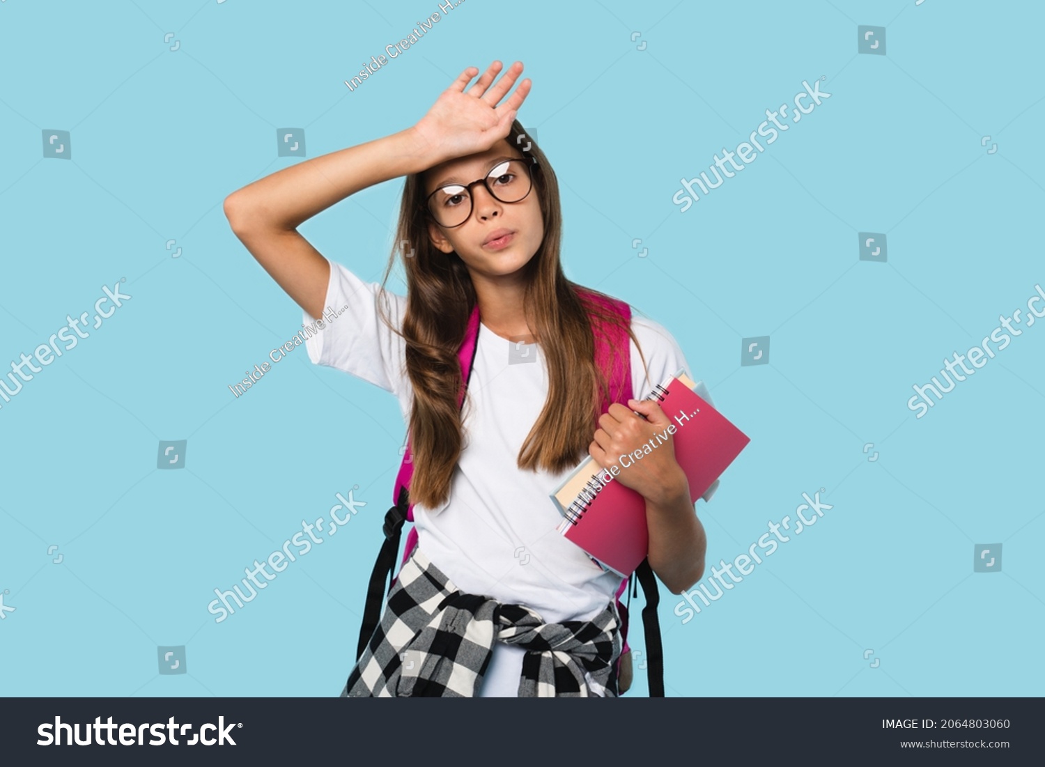 Tired exhausted caucasian smart schoolgirl teenager pupil student feeling sad after school overload, homework, remote distance education, e-learning isolated in blue background #2064803060