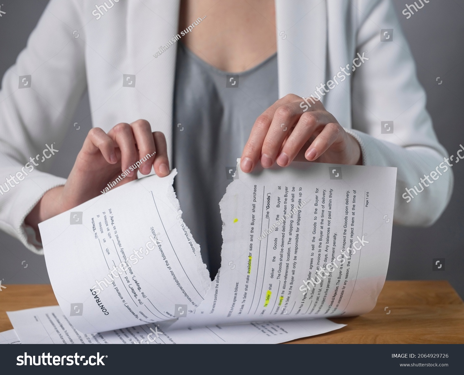 Torn contract in hands. Terminated agreement concept. Ripping paper document and breaching rules. #2064929726