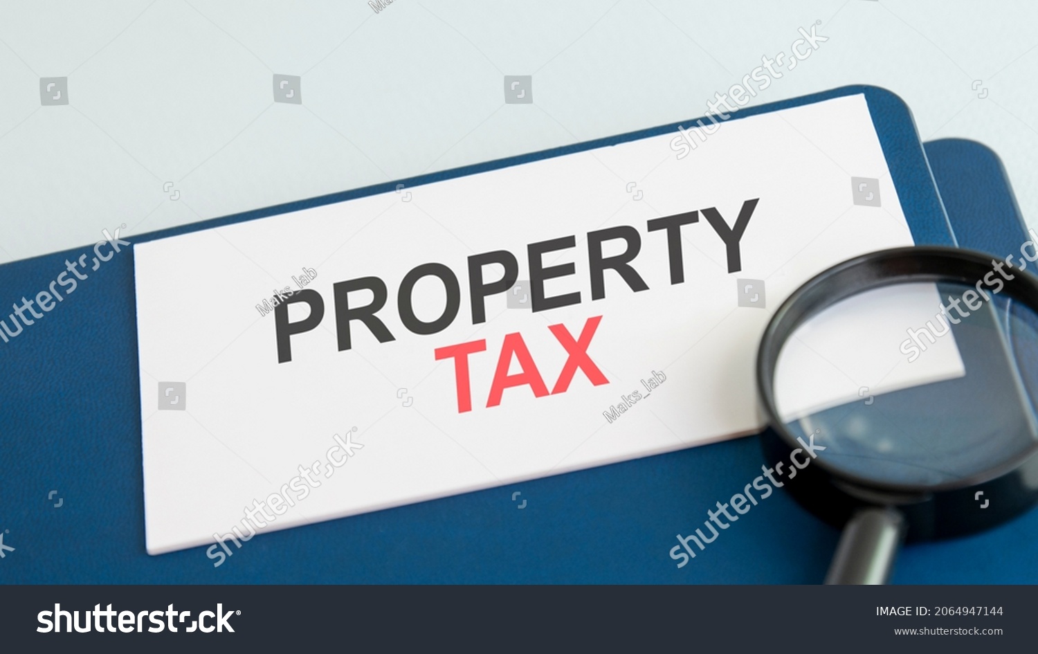 property tax word on white paper card and magnifying lens. you might even make money at it. #2064947144