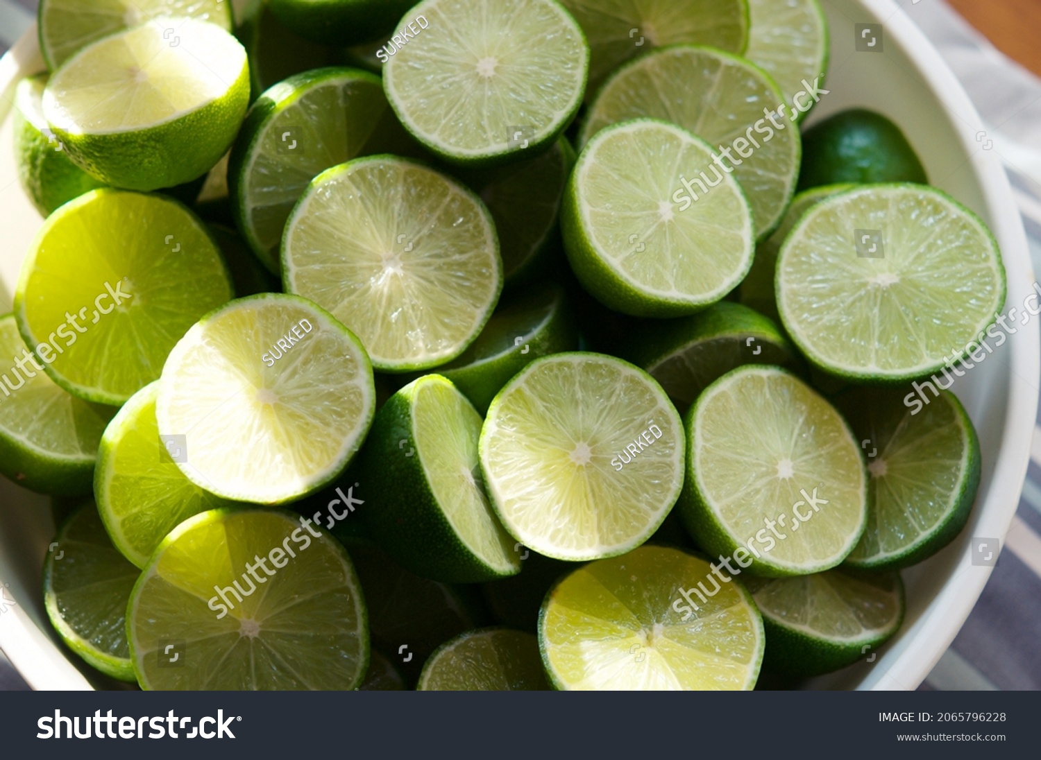 Lime Background with sun light from outside. Close up shot of limes. Selective Focus of sliced lime. Lime is a kind of fruit. The result is very sour for cook the Thai food style #2065796228