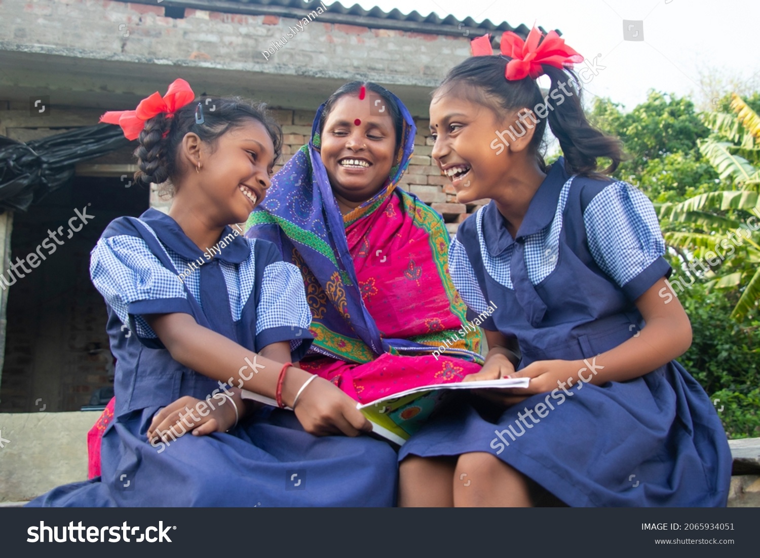 Indian mother helping daughters with homework #2065934051