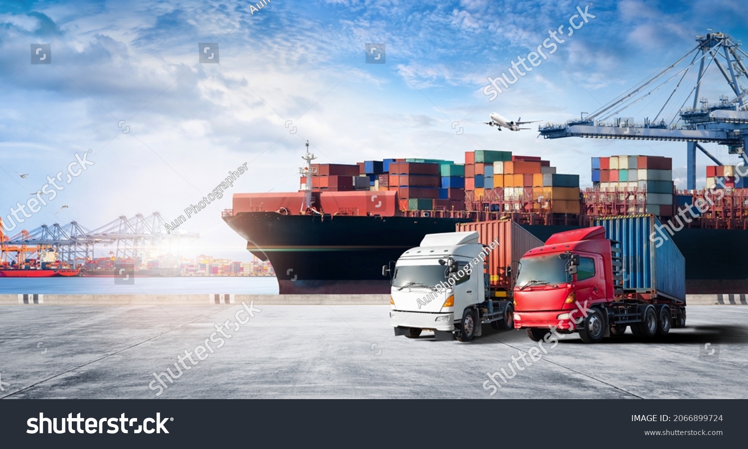 Container cargo freight ship during discharging at industrial port and move containers to container yard by trucks, cargo plane, logistic import export background and transport industry concept #2066899724