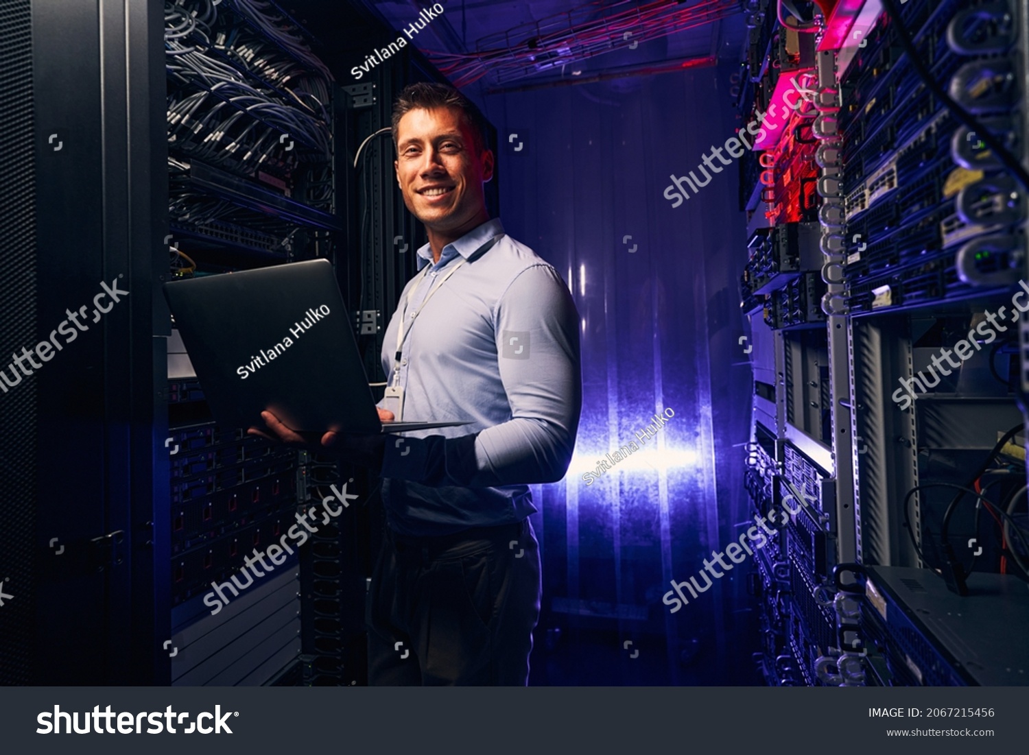 Joyous system administrator with laptop colocation data center #2067215456