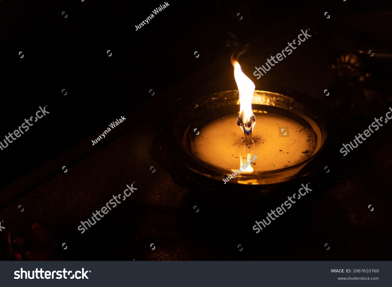 Flame of a candle on a grave. All Saints day. Votive candle on a dark background. All Saints Day 1st November. All Souls Day 2nd November. The Day of The Dead. #2067610760