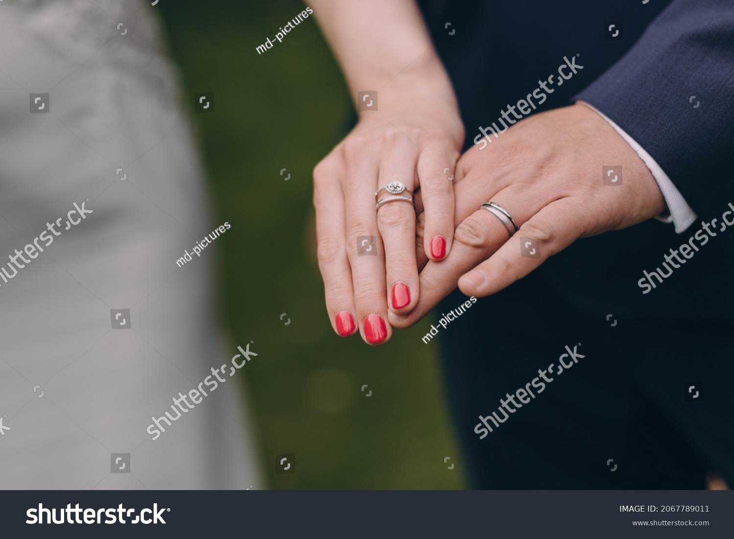 Picture of bride and groom with wedding ring. Young married couple holding hands, ceremony wedding day. Newly wed couple's hands with wedding rings. #2067789011