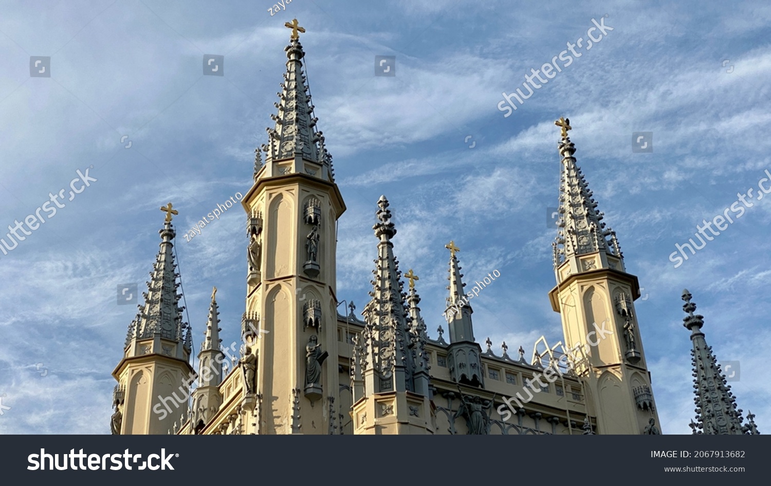 Spire of the Church in the medieval Gothic style. Gothic chapel. Top of the towers. #2067913682