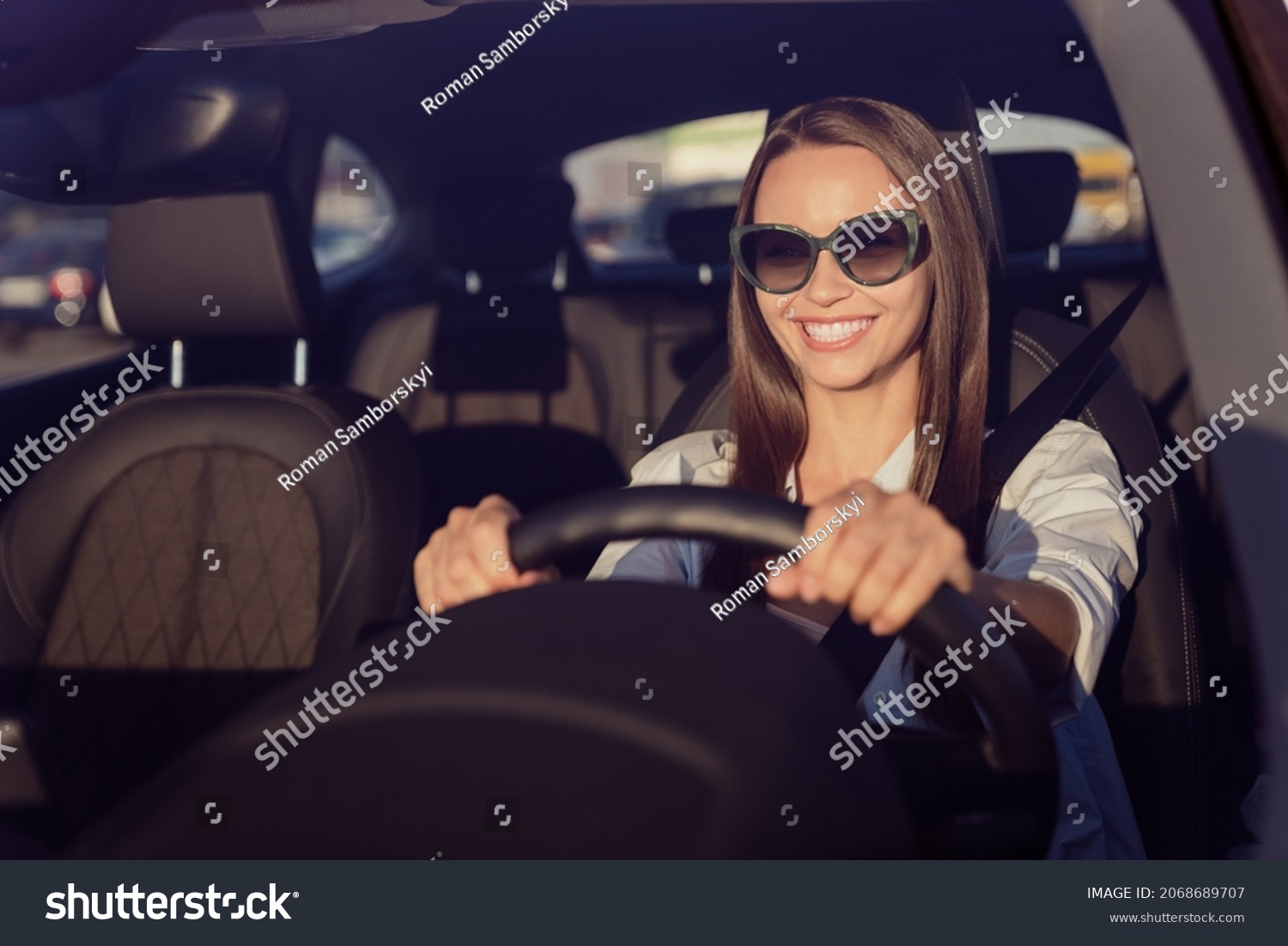 Photo portrait smiling woman wearing sunglass keeping steering wheel in the car #2068689707