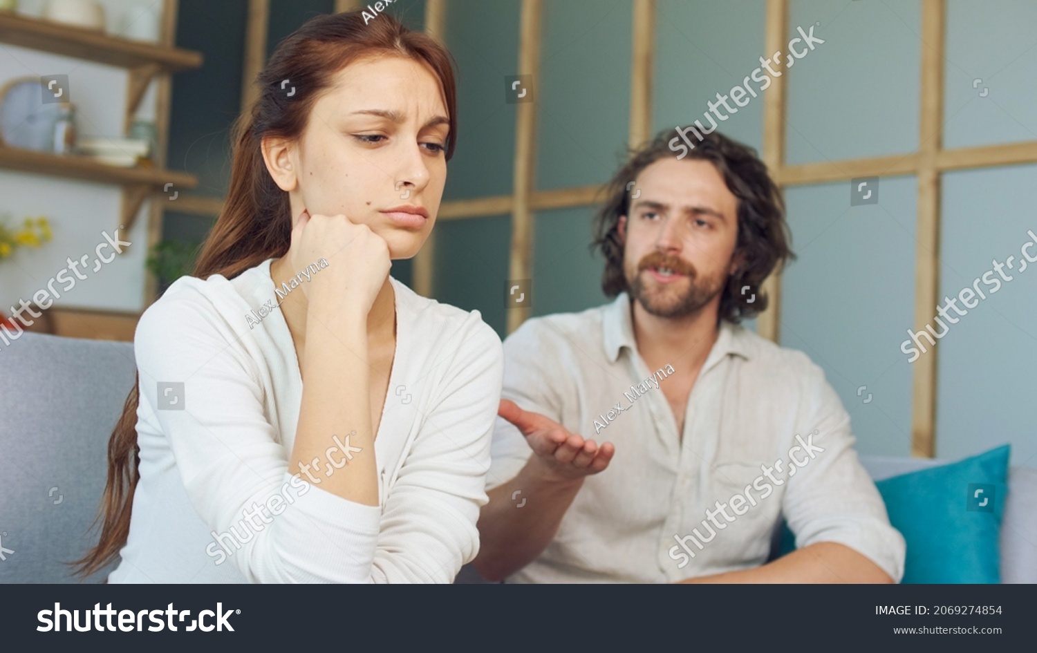 Couple Quarreling Sitting on the Couch at Home, Boyfriend Screams Accusing Girlfriend. Relationship Problems by Reason of Disagreement. The Man and Woman are Arguing. Young Woman Feeling Lonely. #2069274854