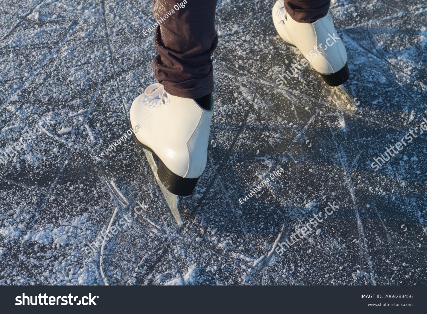 To skate on the ice of a river or lake in winter, white skates slide on the ice in close-up. #2069288456