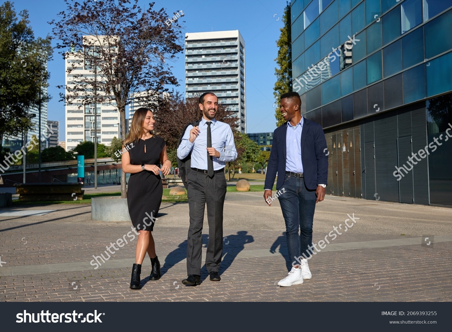 three business people walking down the street and laughing after workday #2069393255