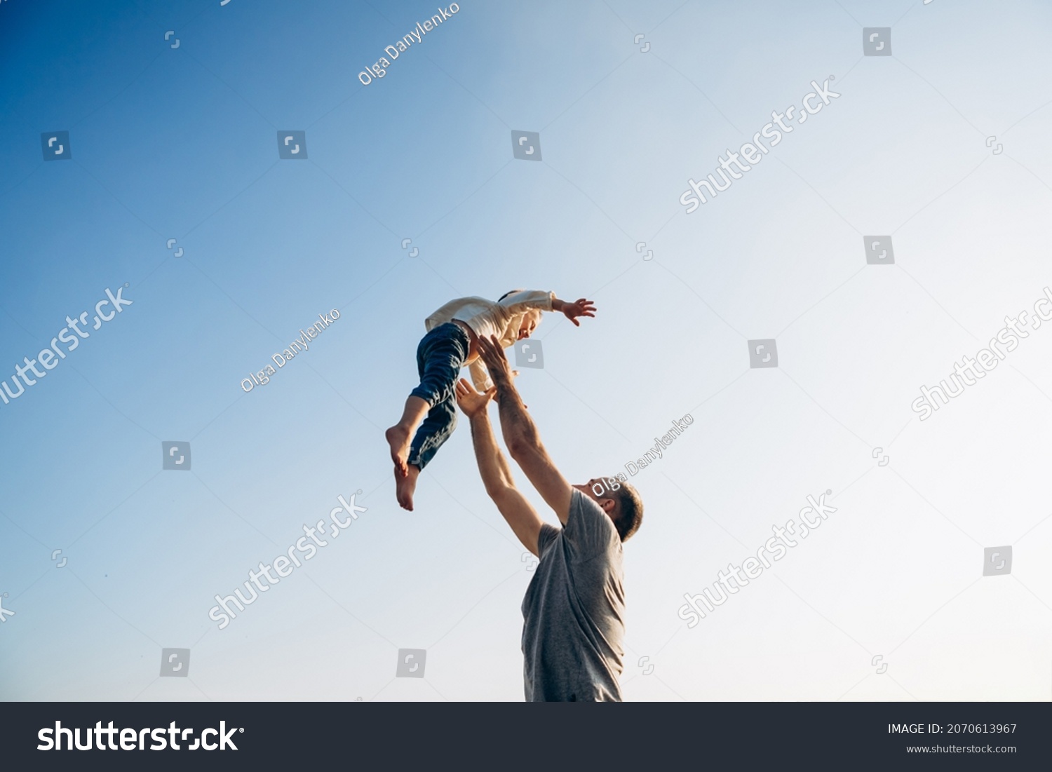 Father and son playing in the park at the sunset time. Family, trust, protecting, care, parenting, summer vacation concept #2070613967