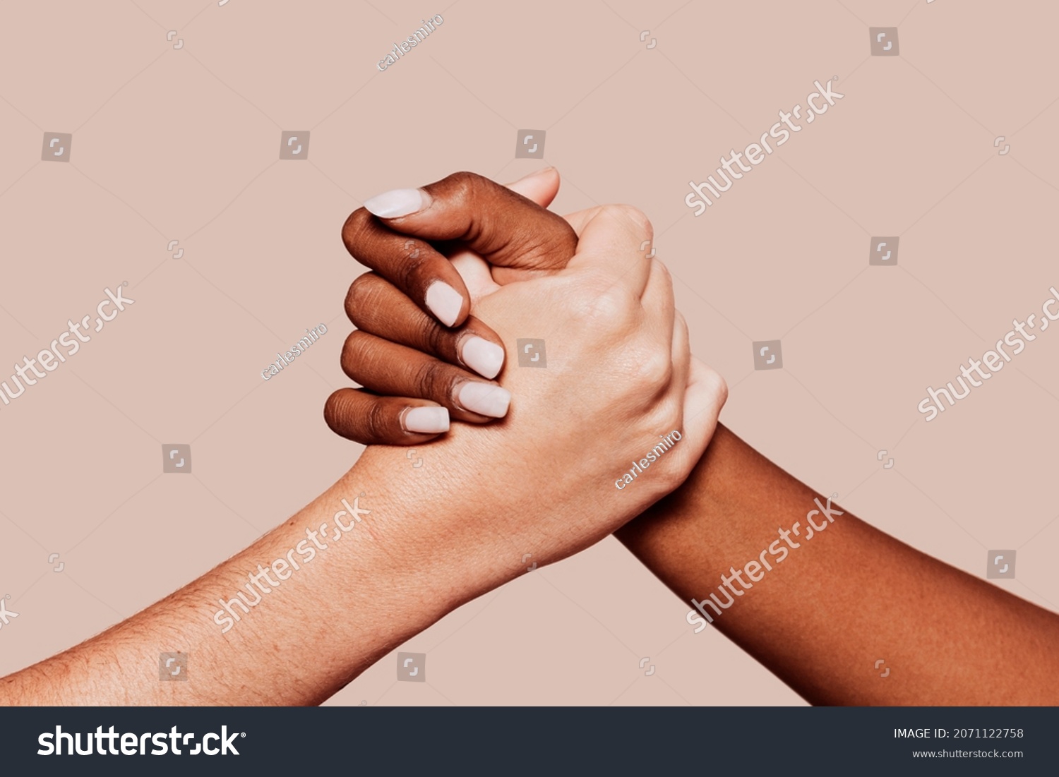 Close up multiracial woman couple with black and caucasian hands holding each other in tolerance unity love and anti racism concept. Studio shot, pastel beige background. #2071122758