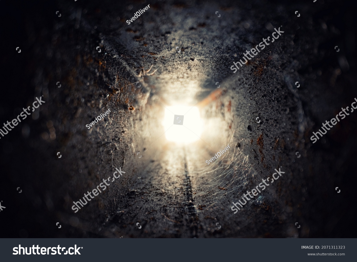 Long illuminated steel tunnel with light at the end #2071311323