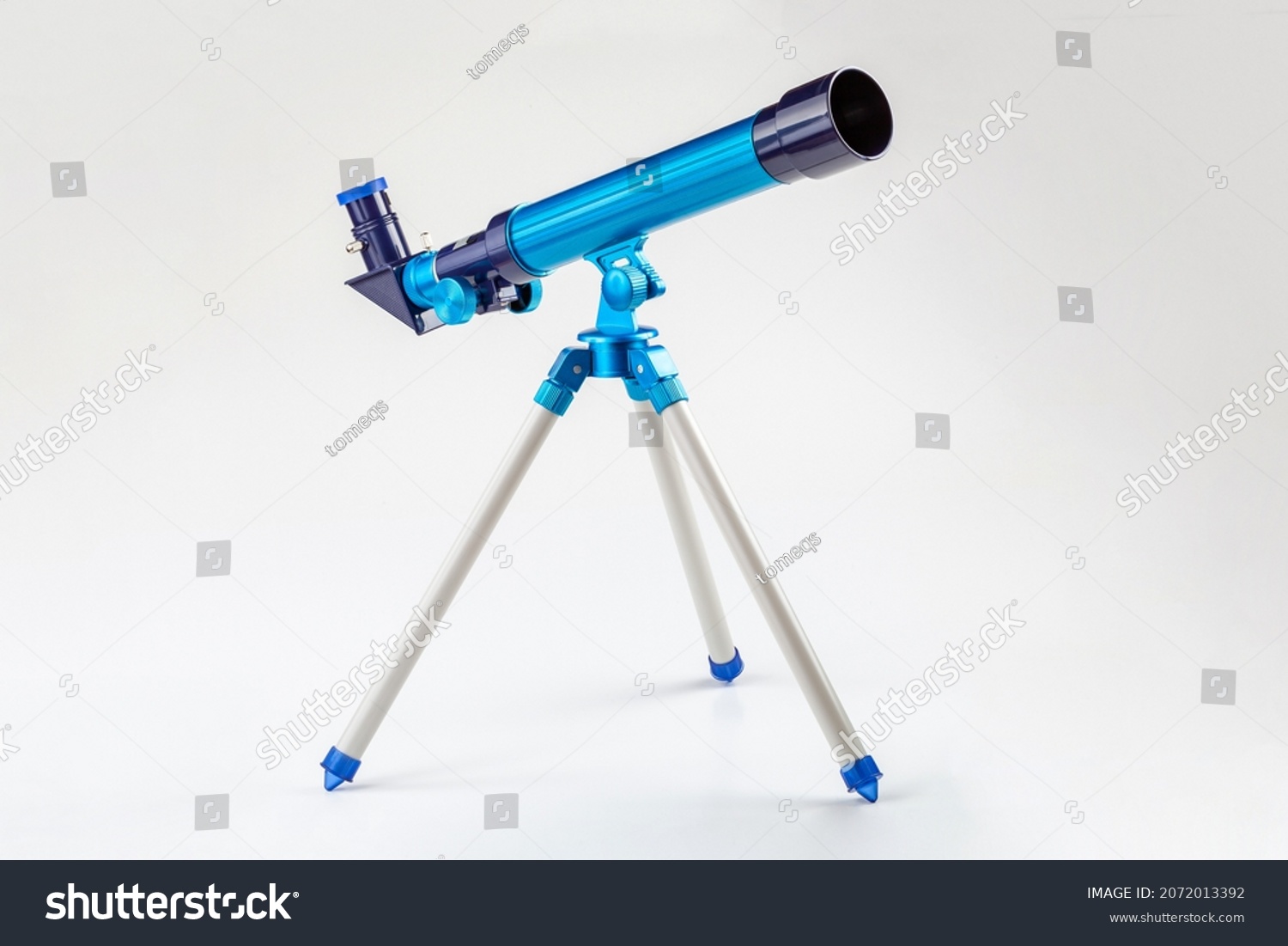 Blue toy telescope on a tripod, single object isolated on white background. Stargazing, space observation science instruments, tools for young kids, children, astronomy hobby conceptual symbol, nobody #2072013392