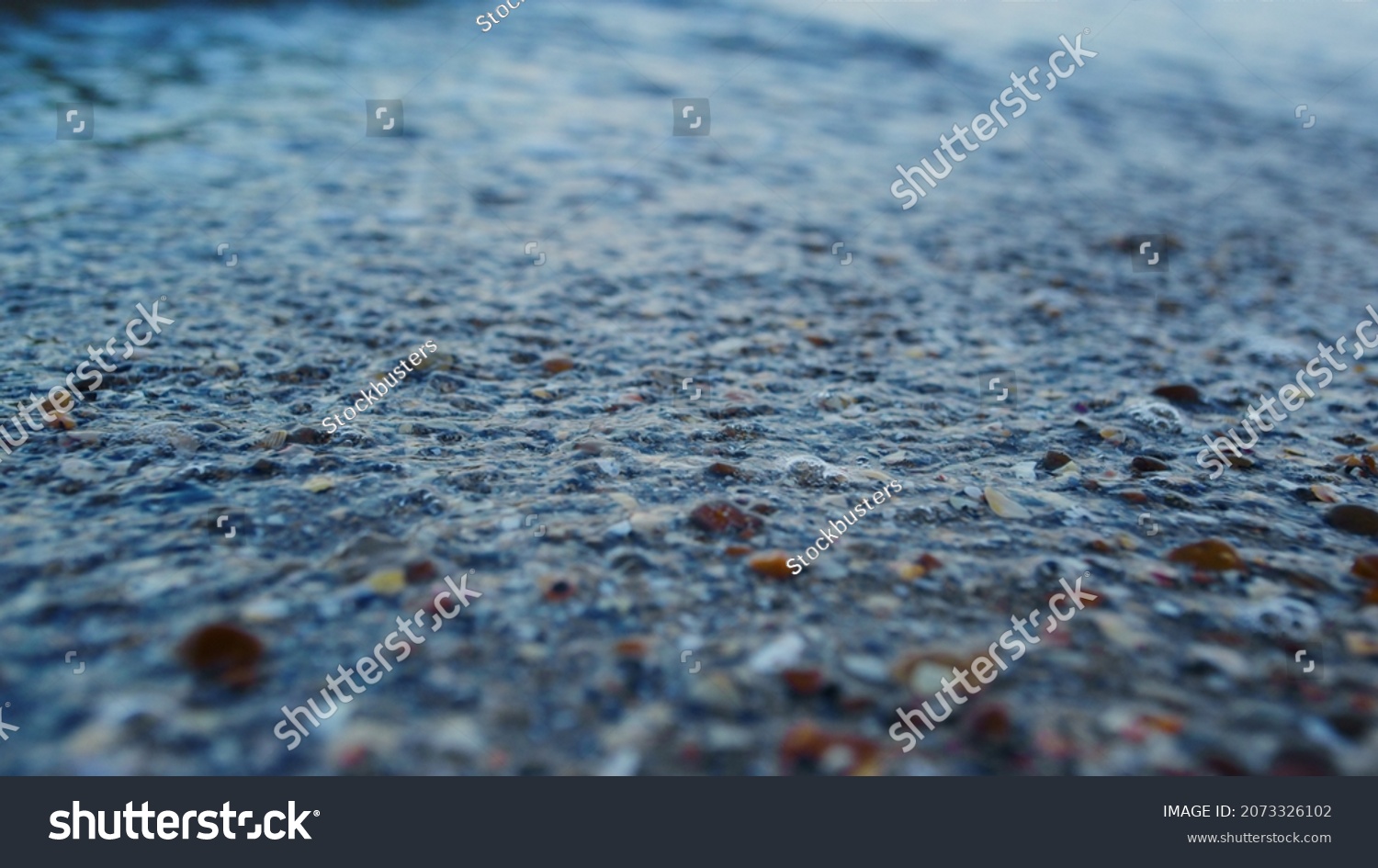 Macro blue sea water splashing seashell sand beach in slow motion. Closeup transparent sea waves water breaking sandy beach coast at morning. Abstract seashore nature background. Travel vacation relax #2073326102