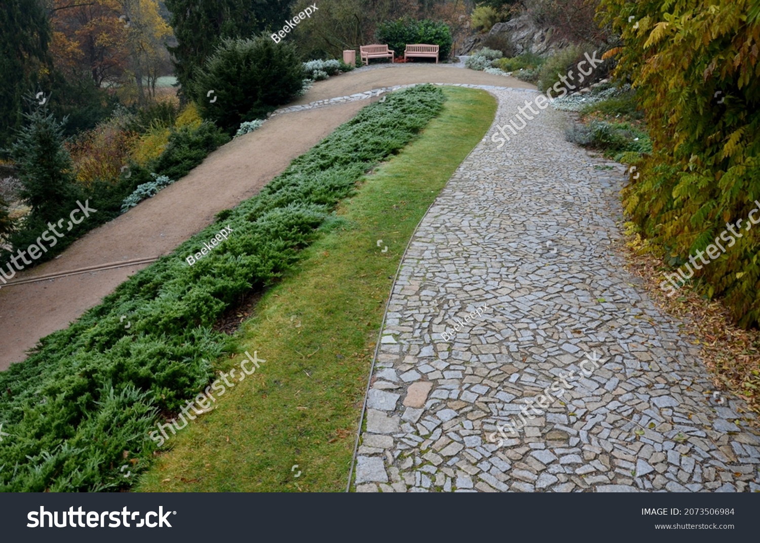 stabilization of the slope with the help of wooden slats, which with the help of wires hold soil on the slope. granite park paths and perennial flower beds with benches. historic garden above lake  #2073506984