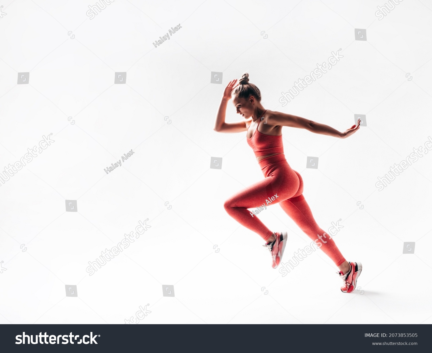 Fitness confident woman in pink sports clothing. Sexy young beautiful model with perfect body. Female isolated  on white in studio. Cheerful and happy. Jumping and running #2073853505