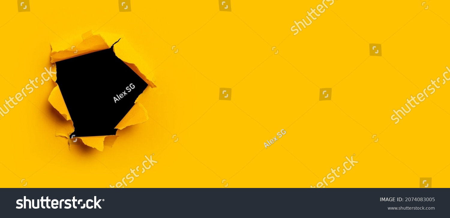 Bright yellow torn paper inside a black hole in a hole. Banner #2074083005