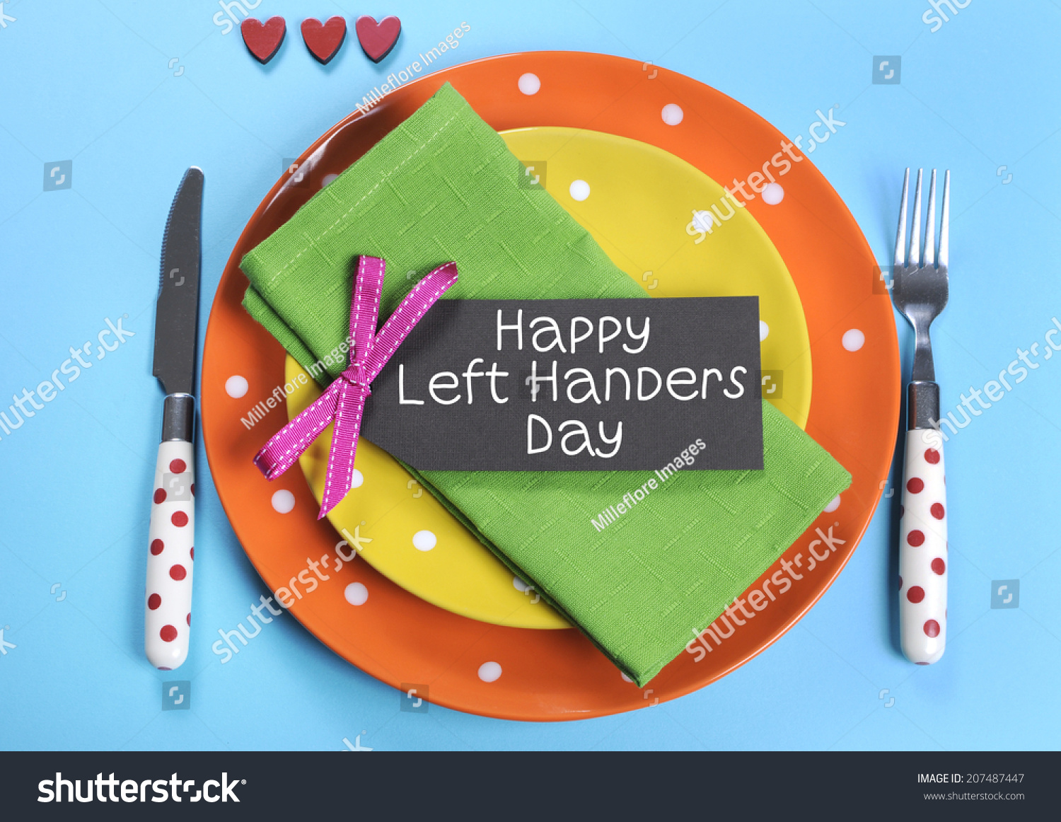 Happy Lefthanders Day, for August 13, International Left-handers Day, with colorful table setting showing reverse cutlery placing, in orange, yellow, pale blue and green polka dot colors. #207487447