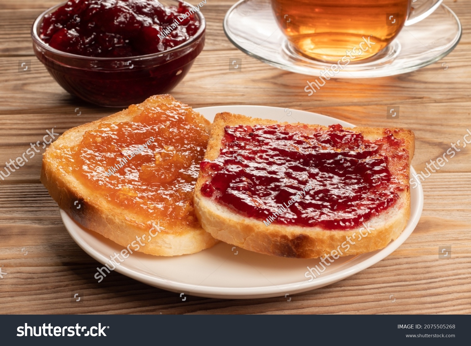 Toasts with red and orange jam on white plate. #2075505268