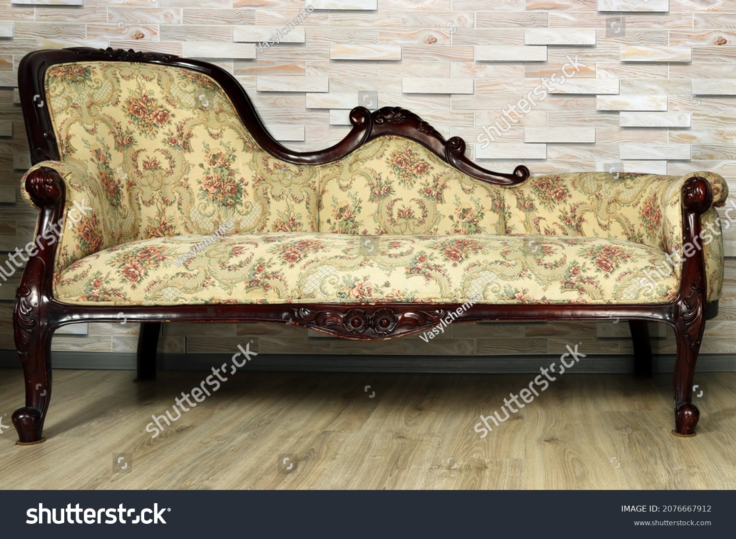 Antique furniture close-up. Sofa banquette in baroque style against the background of a wooden wall. #2076667912