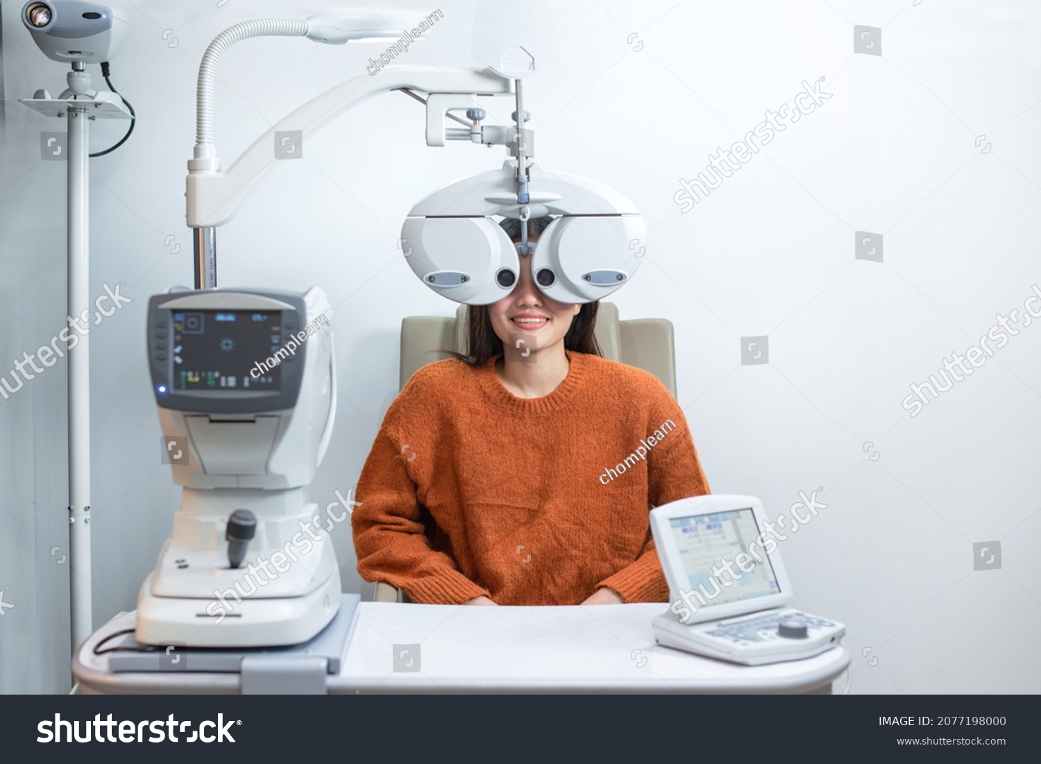Asian beautiful woman looking through auto refractometer in modern ophthalmology clinic, eyesight test with modern equipment #2077198000