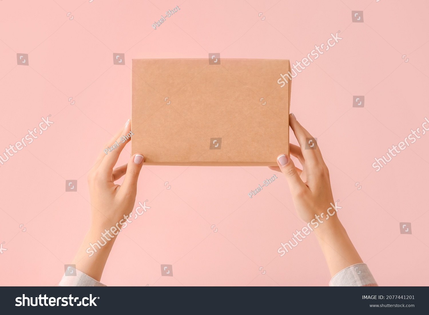 Hands with cardboard box on color background #2077441201