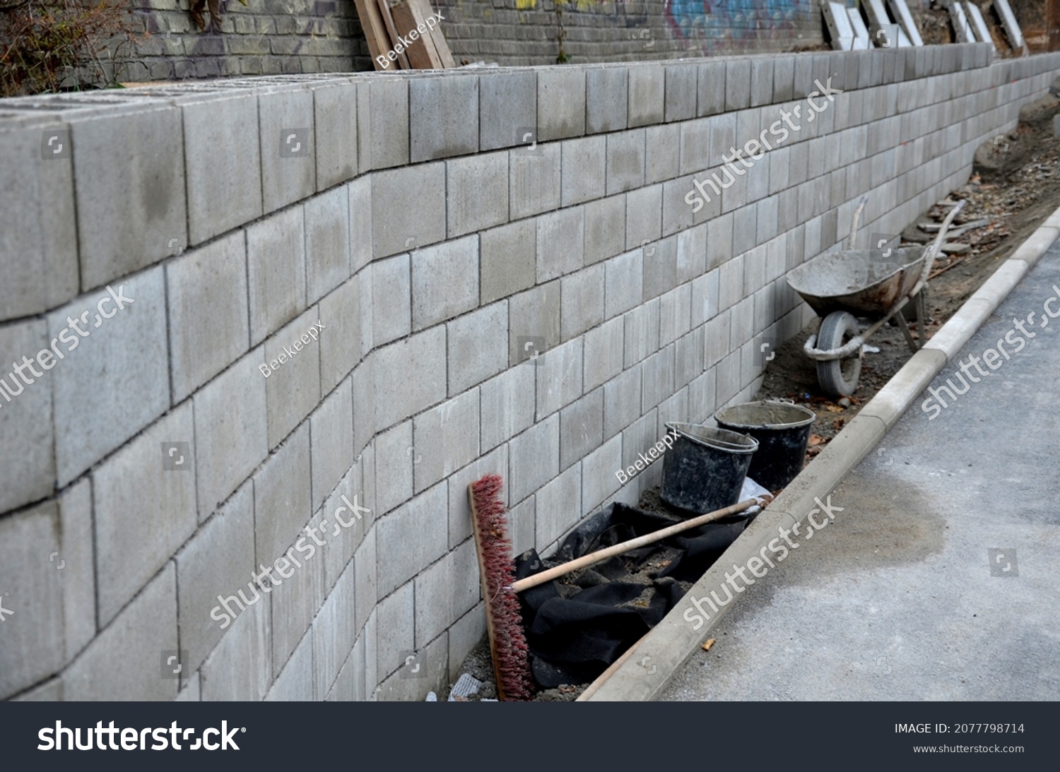 ugly holding a road notch of a bridge forecourt tunnel. retaining wall with concrete grouting is covered with fake, optically prettier wall. fencing with hollow bricks filled with wires, railing,steel #2077798714