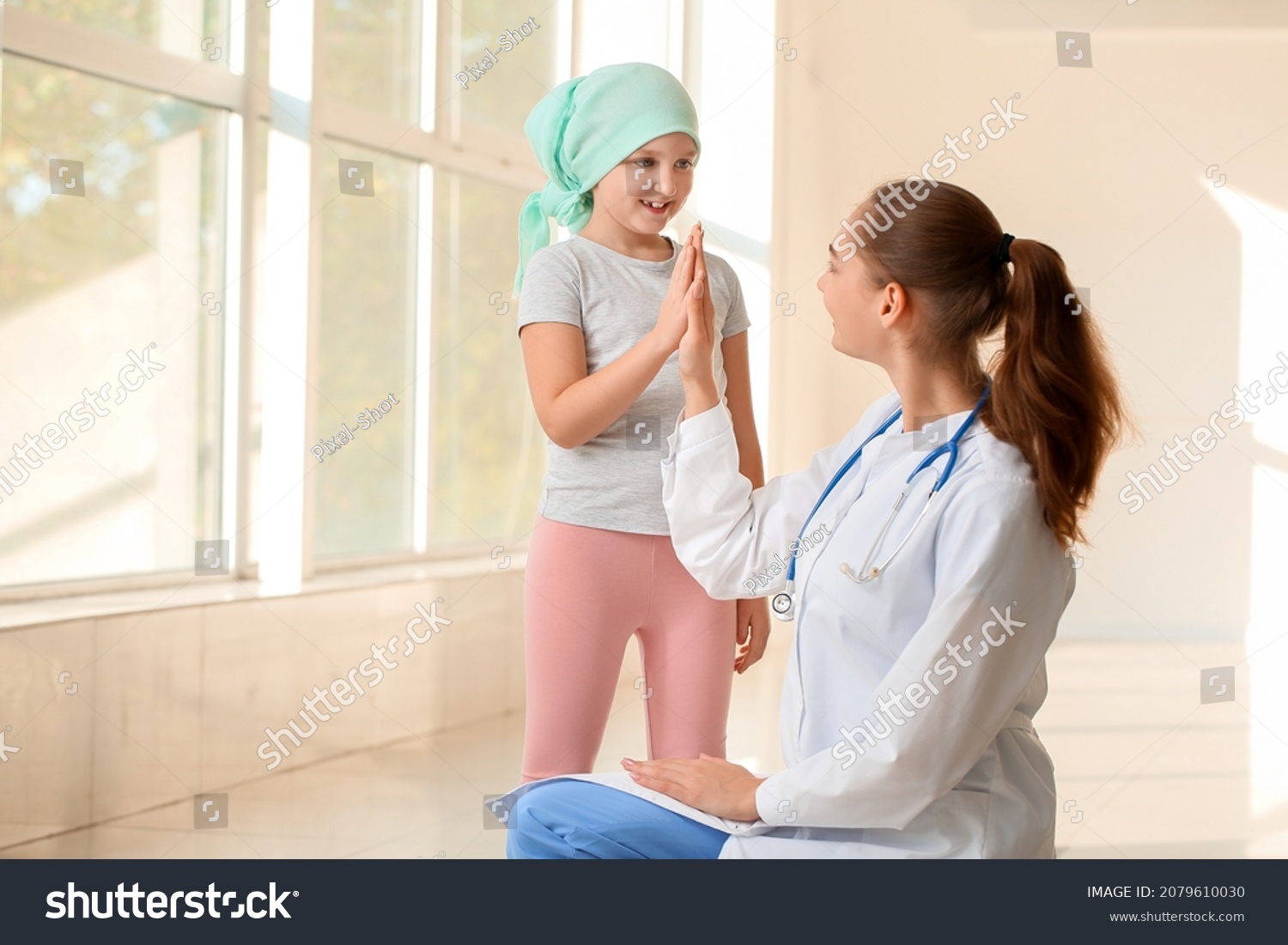 Doctor and little girl in clinic. Childhood cancer awareness concept #2079610030