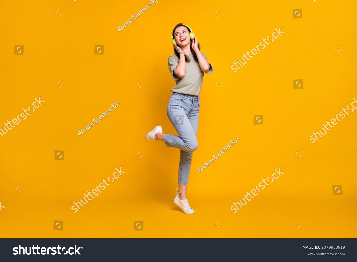 Full length body size view of lovely cheerful girl jumping listening melody isolated over bright yellow color background #2079933919