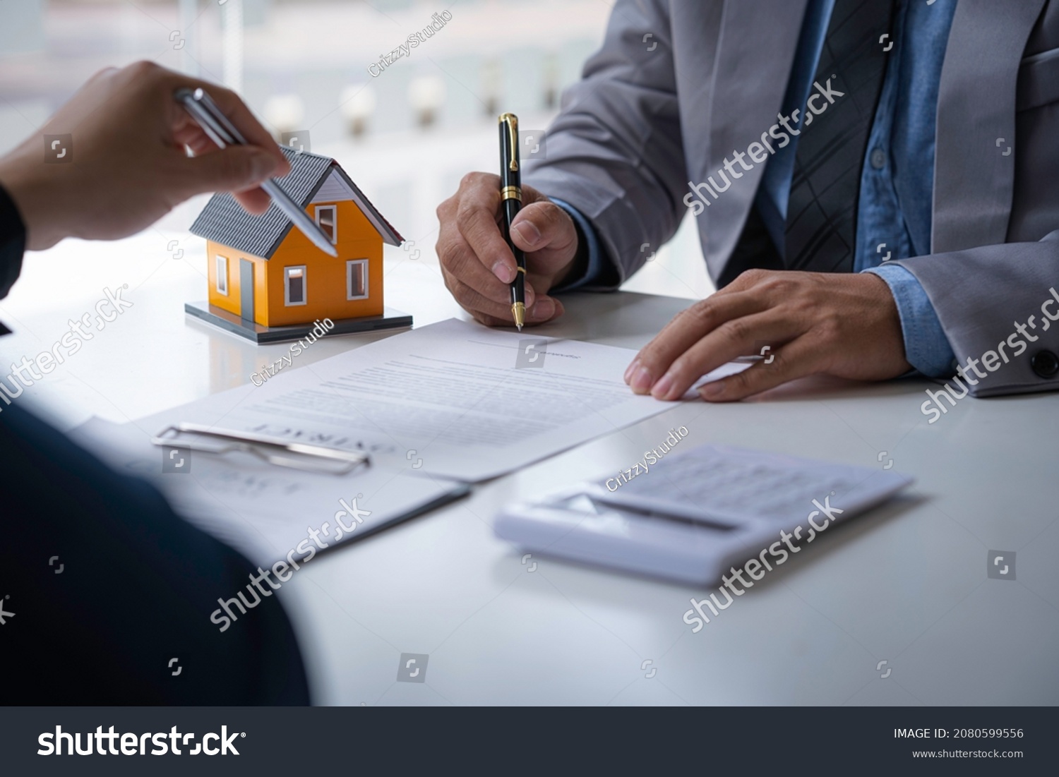 Discussion with a real estate agent, House model with agent and customer discussing for the contract to buy, get insurance or loan real estate or property. #2080599556