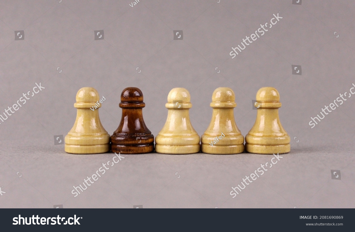 One black chess pawn among whites pawns on gray background #2081690869