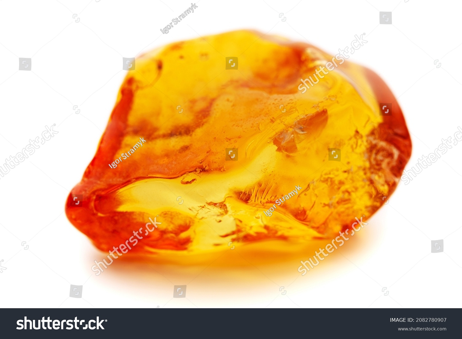 Natural amber. A piece of yellow opaque natural amber on white background. #2082780907