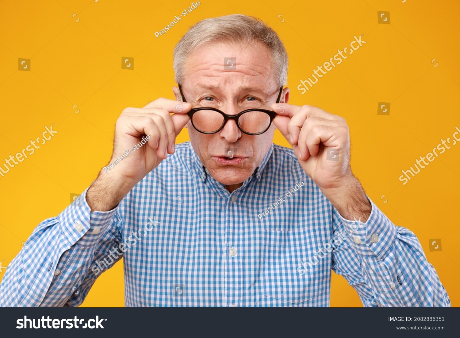 Poor Eyesight. Senior Man Can't See, Squinting Eyes Wearing Eyeglasses Having Problems With Vision, Looking At Camera, Yellow Orange Wall. Ophtalmic Issue In Older Age, Macular Degeneration Concept #2082886351